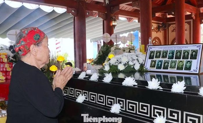 Bà Thuần bên mộ chung của 13 liệt sĩ TNXP hy sinh ở Truông Bồn.