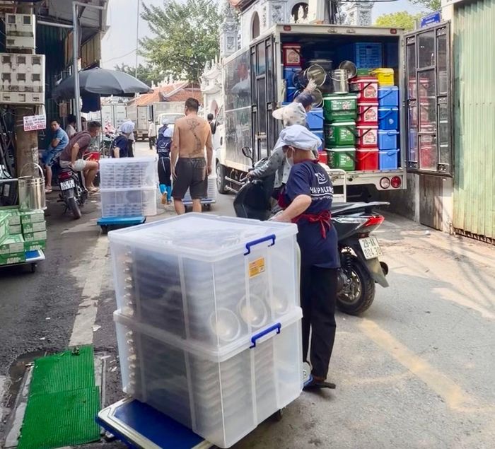 Các suất ăn được chia theo khay, nhân viên dùng xe kéo ra ngoài ngõ mới có thể chuyển lên xe đi đến các trường. (ảnh: Hà Linh)