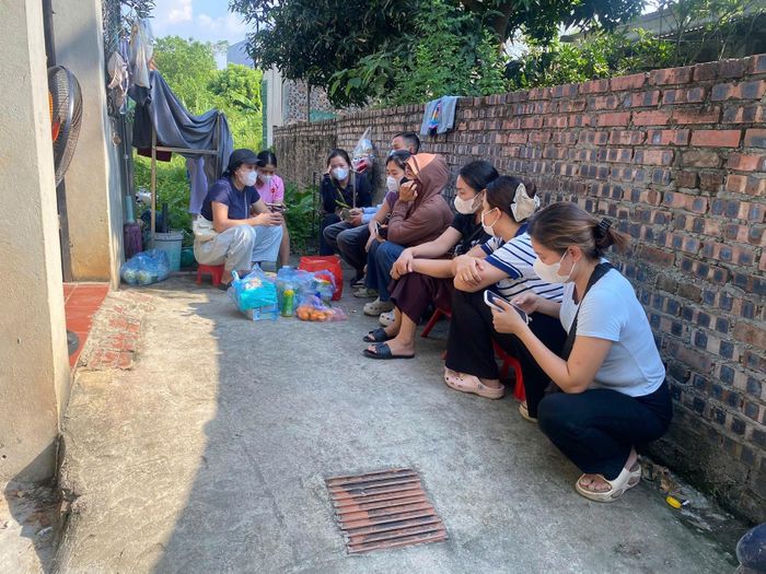 Phụ huynh thay nhau ngồi trực gần bếp ăn của Công ty TNHH Mai Phương và nhà kho được cho là của công ty này để yêu cầu làm rõ. Ảnh: T.N.