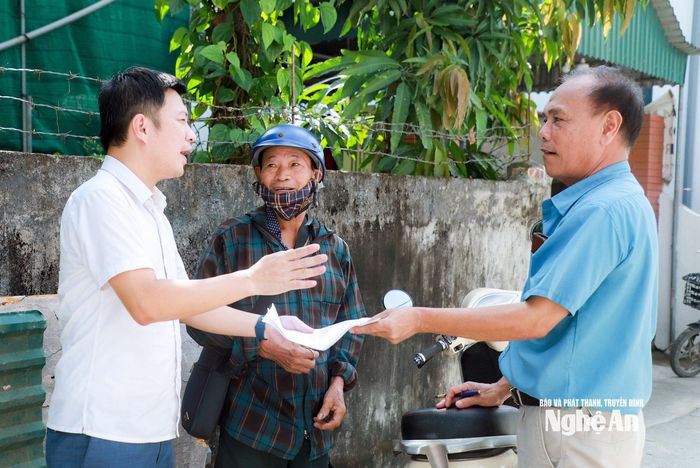 Ông Nguyễn Nhâm Đàm - Giám đốc Trung tâm Phục vụ hành chính công xã Kim Liên (trái) và Trần Đình Hiền - Bí thư Chi bộ xóm Nam Giang, xã Kim Liên (phải) trao đổi, hướng dẫn người dân tiếp tục hoàn thiện các tài liệu, giấy tờ cần thiết để làm thủ tục cấp giấy chứng nhận quyền sử dụng đất. Ảnh: Thành Duy