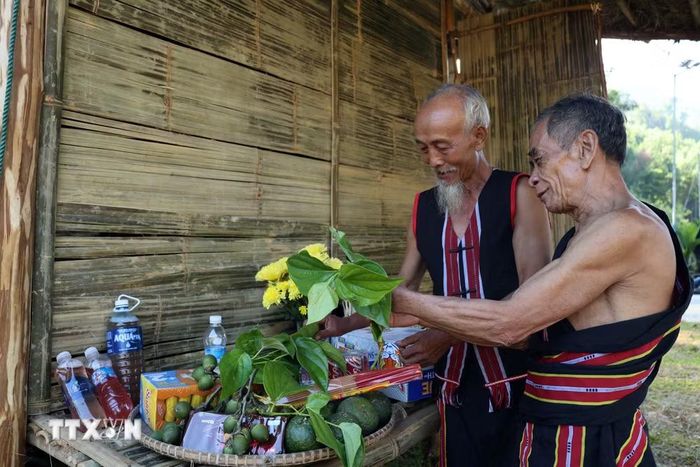 Hai già làng chuẩn bị lễ vật trước khi bước vào Lễ cúng máng nước của đồng bào M’Nông. (Ảnh: Đỗ Trưởng/TTXVN)