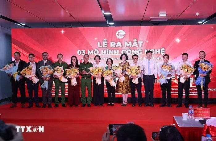 Đại diện lãnh đạo Ủy ban Nhân dân Thành phố Hồ Chí Minh chúc mừng các đơn vị thực hiện 3 mô hình chuyển đổi số phục vụ người dân. (Ảnh: Hồng Đạt/TTXVN)