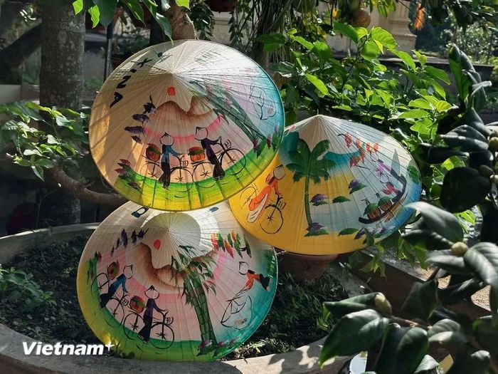 Những chiếc nón được vẽ họa tiết thủ công, kết hợp nét truyền thống với sự sáng tạo theo yêu cầu. (Ảnh: Hồng Ngọc/Vietnam+)