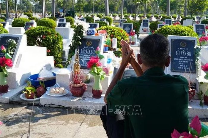 Thương binh Đào Văn Trường, anh trai của liệt sĩ Đào Văn Hải, ngồi lặng trước ngôi mộ của em trai mình tại Nghĩa trang Liệt sĩ thành phố Đồng Nai.