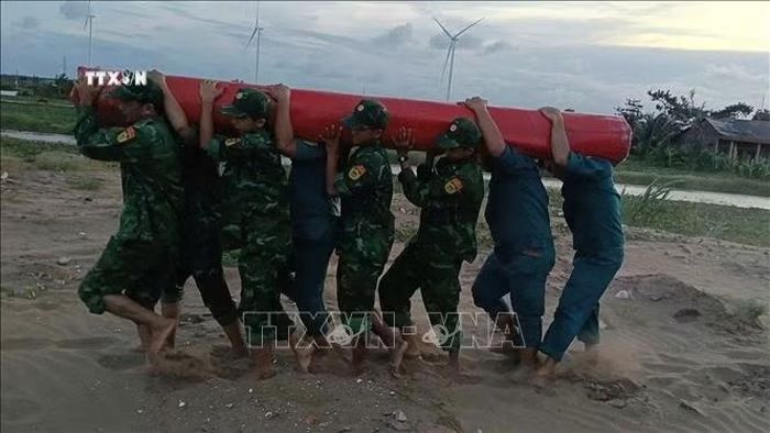 Lực lượng bộ đội Biên phòng tỉnh Vĩnh Long hỗ trợ địa phương vận chuyển trang thiết bị khắc phục sự cố sạt lở. Ảnh: TTXVN phát