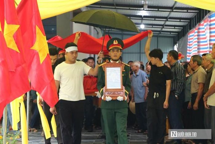 Dù trời đổ mưa lớn, đông đảo bà con nhân dân và đại diện chính quyền địa phương vẫn tề tựu đông đủ để tiễn đưa liệt sĩ Phạm Duy Trinh về nơi an nghỉ cuối cùng.