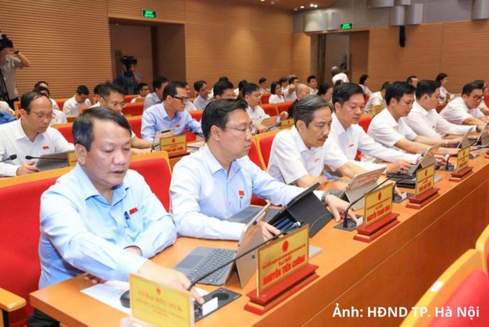Các đại biểu biểu quyết thông qua dự thảo nghị quyết.