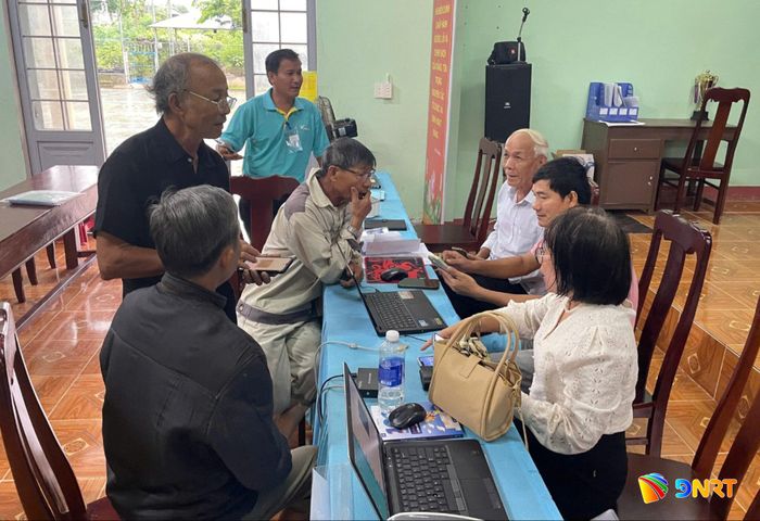Người dân được cán bộ khối phố tham gia hướng dẫn các thủ tục hành chính trên điện thoại thông minh. Ảnh: QUANG SƠN.