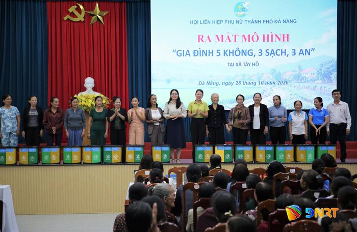 Các hộ gia đình tham gia mô hình nhận thùng rác 2 ngăn từ lãnh đạo Hội Liên hiệp phụ nữ thành phố. Ảnh: ALĂNG NGƯỚC