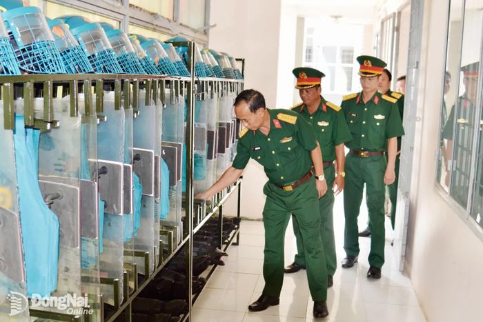 Đại tá Nguyễn Bá Phú, Phó Chỉ huy trưởng Bộ Chỉ huy Quân sự thành phố kiểm tra nền nếp chính quy khu vực treo móc đồ của lực lượng dân quân thường trực, Ban Chỉ huy Quân sự xã Phú Hòa. Ảnh: Phạm Khoa
