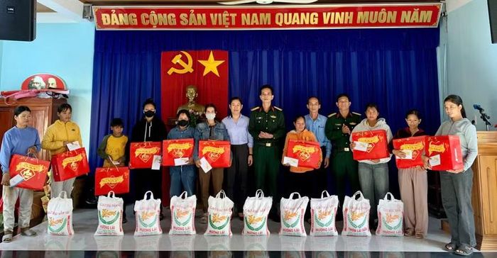 Đại tá Đỗ Ngọc Sơn - Chính ủy Trung tâm Huấn luyện quân sự quốc gia 2 (thứ 7 từ phải sang) cùng cán bộ Trung tâm trao tặng quà cho bà con khó khăn xã Bình Phú nhân dịp tết Bính Ngọ 2026. Ảnh: ĐVCC