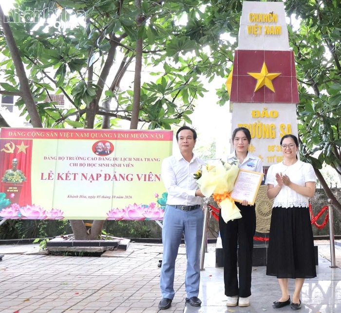 Lãnh đạo Đảng ủy Trường Cao đẳng Du lịch Nha Trang trao quyết định, tặng hoa chúc mừng đảng viên mới Huỳnh Thị Mỹ Lệ.