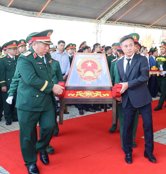 Đồng chí Nguyễn Việt Hùng cùng các đại biểu và lực lượng tiêu binh di chuyển các hài cốt liệt sĩ đến ô mộ để an táng.