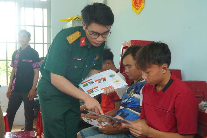 2 Cán bộ Đoàn KT-QP 720 phát tờ rơi tuyên truyền pháp luật đến bà con