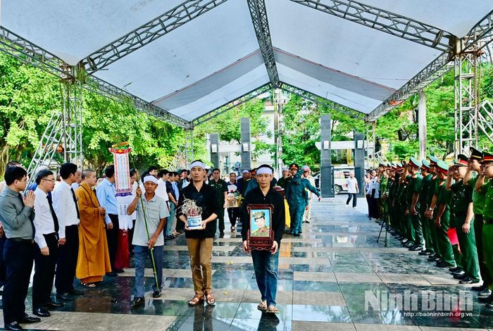 Thân nhân và lực lượng vũ trang thực hiện nghi thức dâng hương, rước di ảnh liệt sĩ Lê Quang Trung về nơi an nghỉ cuối cùng tại Nghĩa trang Liệt sĩ Tam Điệp.