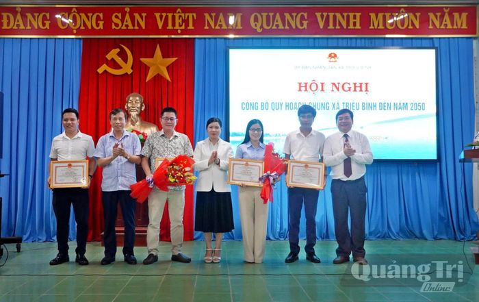 Đại diện lãnh đạo xã Triệu Bình trao giấy khen cho các tập thể, cá nhân có thành tích trong công tác lập quy hoạch - Ảnh: M.T