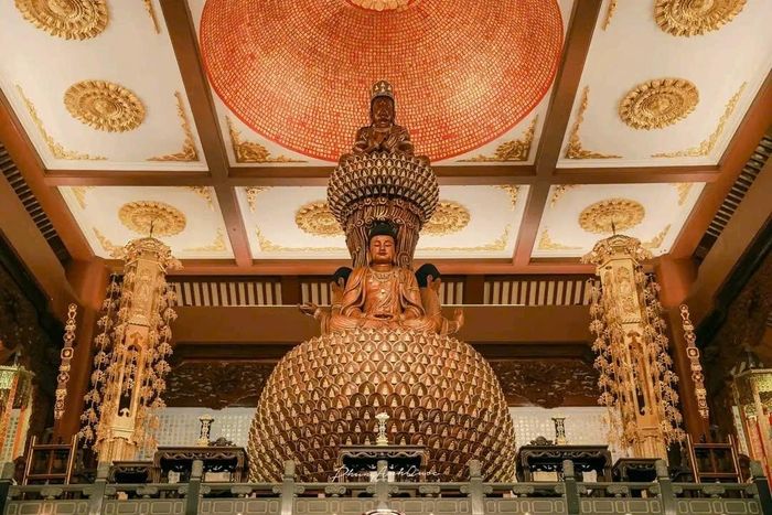 Tôn tượng Tam thân Phật trên tòa sen nhiều cánh tại Giới Đài viện, nổi bật dưới trần khắc giới kinh Tỳ-kheo đầy trang nghiêm. Ảnh: Tường Quang.