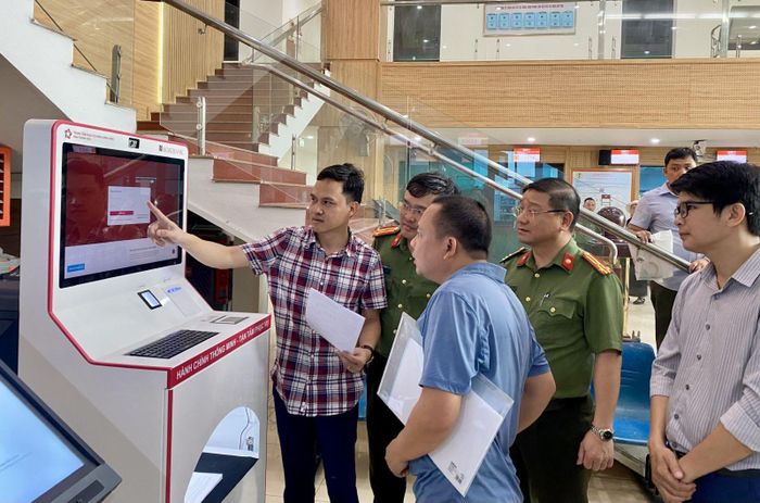 Người dân hào hứng trải nghiệm thực hiện thủ tục hành chính trên Kiosk thông minh tại Trung tâm Phục vụ hành chính công Công an tỉnh Thanh Hóa. Ảnh: Hà Phương