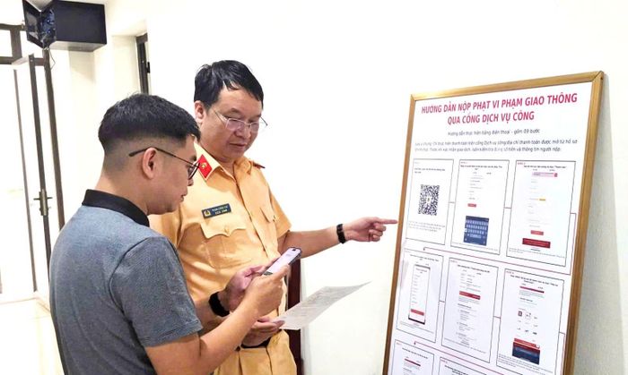 Cảnh sát giao thông hướng dẫn người dân thực hiện thao tác nộp phạt vi phạm hành chính qua Cổng dịch vụ công.