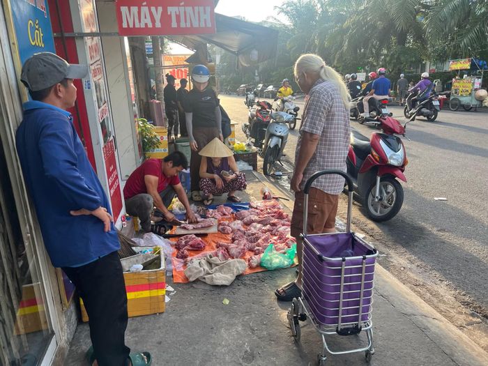 Thịt heo để trên tấm bạt ở lề đường.