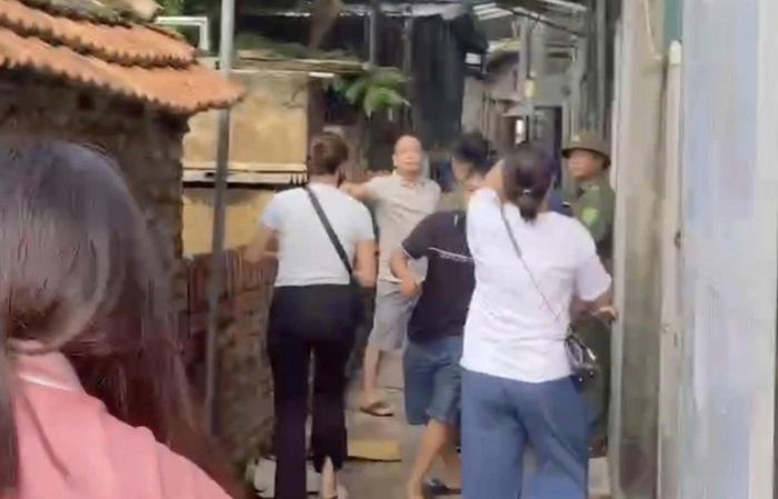 Phụ huynh và một số người được cho là của công ty cung cấp thực phẩm xảy ra xô xát trước cửa nhà kho. (Ảnh cắt từ clip)