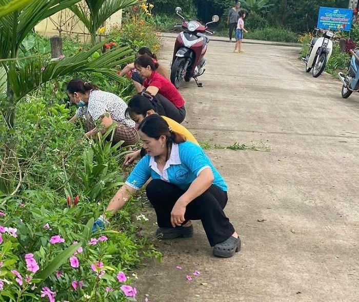 Các Chi hội Phụ nữ ở xã Phú Xuyên tập trung chăm sóc tuyến đường hoa. Ảnh: PV