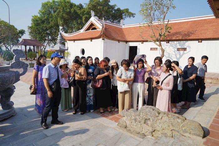 Đoàn khảo sát của Sở Văn hóa, Thể thao và Du lịch Hà Nội nghe giới thiệu về hai đôi rồng đá được dựng năm 1629, có niên đại thời hậu Lê mang biểu tượng của quyền lực và sự tinh tế trong nghệ thuật điêu khắc đá. Ảnh: Nam Pháp