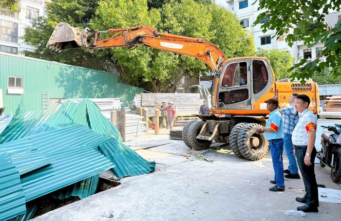 Chủ tịch UBND phường Thanh Liệt Bùi Huy Hoàng (bìa phải) chỉ đạo tại hiện trường. Ảnh: PV