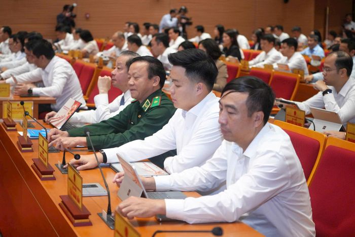Các đại biểu thực hiện biểu quyết thông qua nghị quyết. Ảnh: Thành Thái Hùng