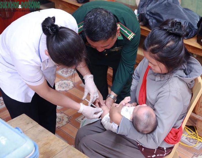Cán bộ Trạm Y tế xã Môn Sơn phối hợp với lực lượng quân dân y Đồn Biên phòng Môn Sơn tổ chức tiêm chủng cho trẻ em Đan Lai, góp sức chăm sóc sức khỏe đồng bào vùng biên. Ảnh: V. Đồng