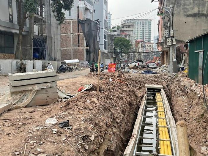 Hệ thống cống thoát nước đang dần hình thành. Tại một đoạn tuyến, rãnh đào sâu được bố trí các cấu kiện bê tông, bên trong có những đường ống màu vàng chạy dọc theo công trình. Ảnh: Phúc Đức