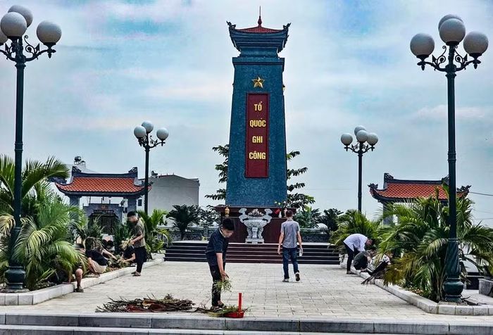 Rời hội trường, 25 thanh thiếu niên cùng ra nghĩa trang liệt sĩ trên địa bàn xã để quét dọn, thu gom lá khô và nhổ cỏ dưới chân đài tưởng niệm.