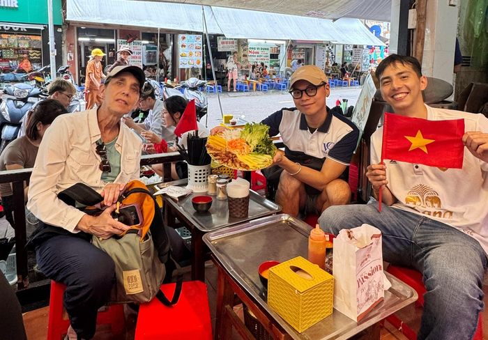 Đỗ Minh (ở giữa) chụp cùng các du khách khi ăn ở quán nem nướng. Ảnh: NVCC.