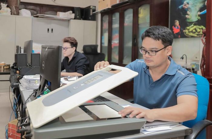 Nhân viên Bảo tàng Phụ nữ Việt Nam tiến hành quét ảnh, số hóa và cập nhật thông tin hiện vật lên phần mềm chuyên dụng. Ảnh: Phan Phương