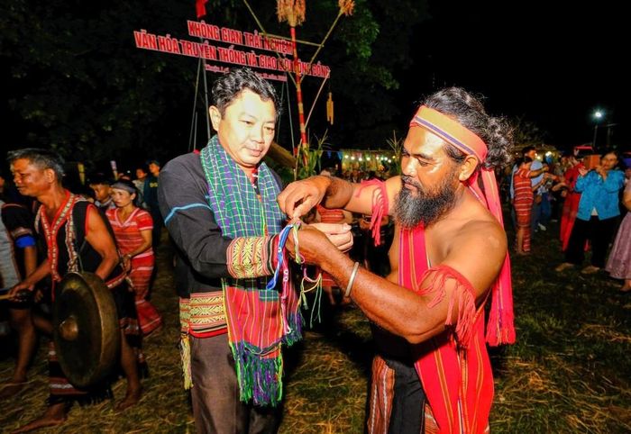 Người có uy tín trong cộng đồng trao vòng bình an cho đại biểu và du khách đến tham dự Lễ cầu an tại Tuần lễ “Phú Riềng Đỏ” (xã Thuận Lợi, thành phố Đồng Nai). Ảnh: Nhật Bình – TTXVN