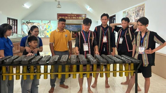 Khách du lịch trải nghiệm đánh đàn đá tại Khu bảo tồn văn hóa dân tộc S’tiêng Sóc Bom Bo (xã Bom Bo, thành phố Đồng Nai). Ảnh: Nhật Bình – TTXVN