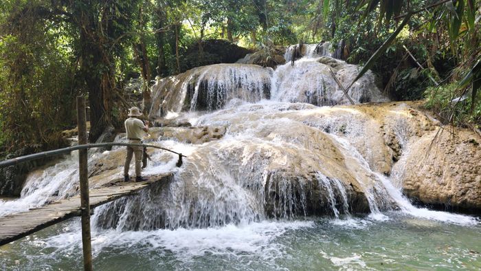 Ông Vi Văn Hùng (áo đỏ bên trái), Phó Trưởng phòng Văn hóa - Xã hội xã Cổ Lũng giới thiệu với phóng viên báo Thể thao và Văn hóa về thác Hiêu. Ảnh: Huy Thông