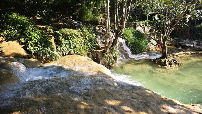 Giữa những tán cây rừng, thác Hiêu hiện ra với nhiều tầng nước nối tiếp. Ảnh: Huy Thông