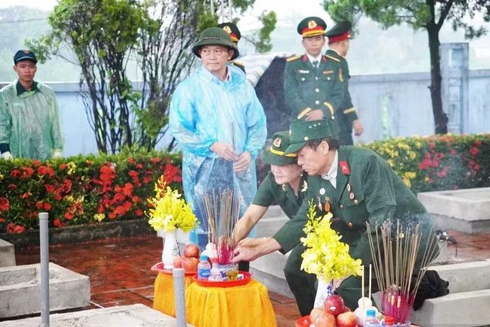 Cựu chiến binh thắp hương lên phần mộ liệt sĩ. (Ảnh: Lâm Quang Huy)