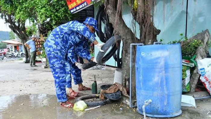 Cán bộ, chiến sĩ Bộ Tư lệnh Vùng Cảnh sát biển 4 xử lý các vật dụng đọng nước dễ phát sinh muỗi. (Ảnh: ĐỨC THÁI)