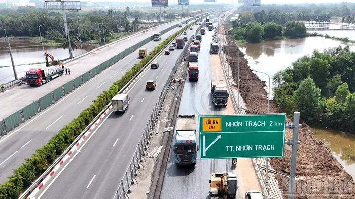 Ghi nhận của phóng viên Báo Nhân Dân sáng 29/10, tại gói thầu số 2 có hàng trăm phương tiện được huy động để thi công thảm nhựa, hoàn thiện lan can bên lề đường.
