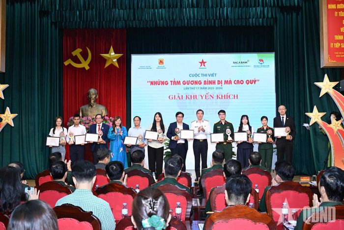 Thiếu tướng Ngô Minh Thuấn và đồng chí Vũ Thu Hằng trao giải Khuyến khích tặng các tác giả, nhóm tác giả và nhân vật. 