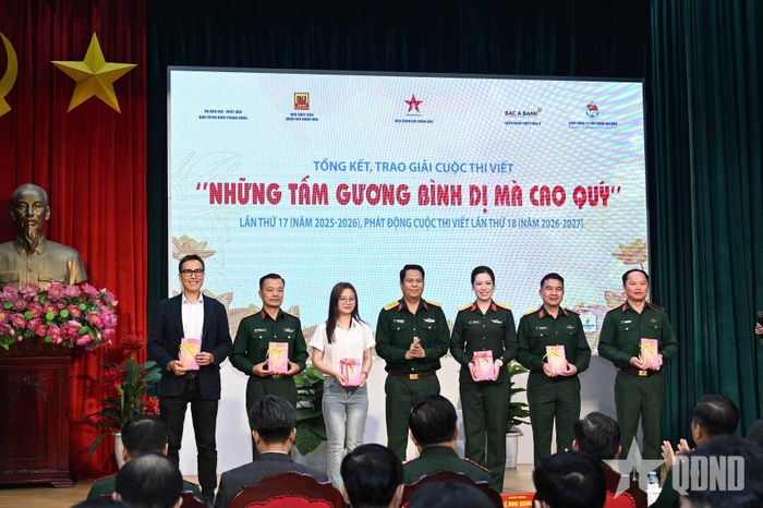 Đại tá Phạm Văn Trường trao sách "Những tấm gương bình dị mà cao quý" tặng các tác giả đoạt giải.  