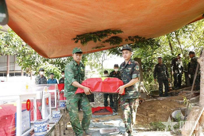   Lực lượng chức năng di chuyển hài cốt liệt sĩ về nhà quàn tại Nghĩa trang Liệt sĩ Tông Khao.  