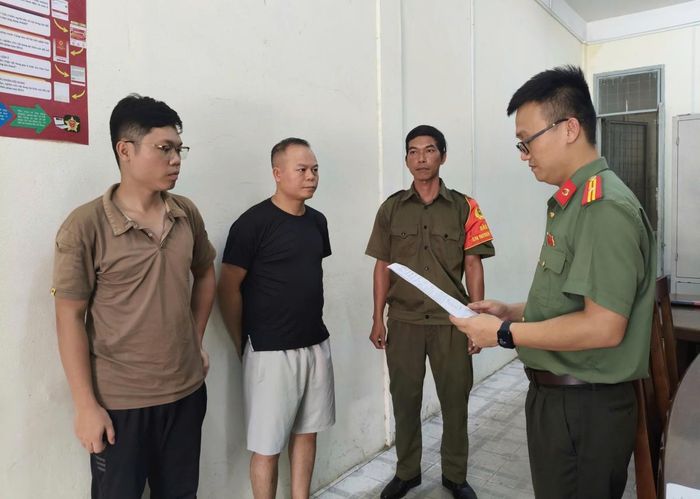 Cơ quan An ninh điều tra Công an TP Đà Nẵng tống đạt các quyết định đối với Chu Đức Anh (áo đen) và Nguyễn Trung Hiếu (ngoài cùng bên trái)