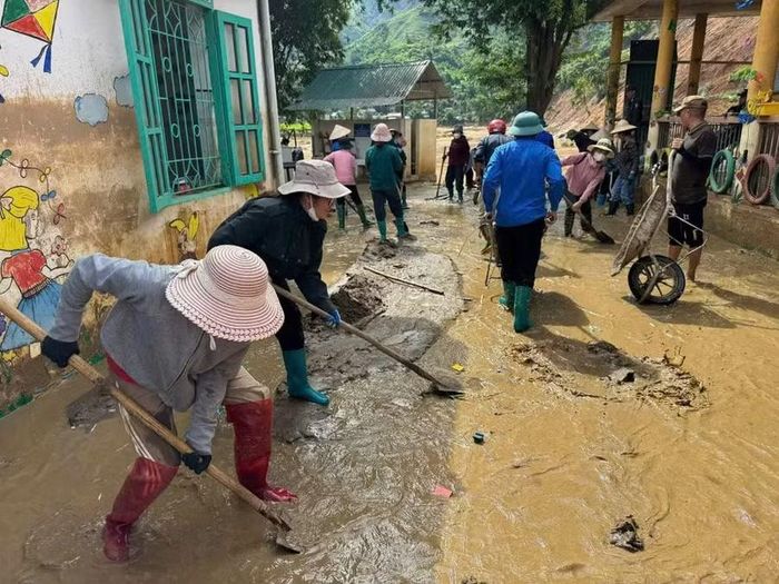 Các giáo viên cùng người dân khắc phục hậu quả sau thiên tai.