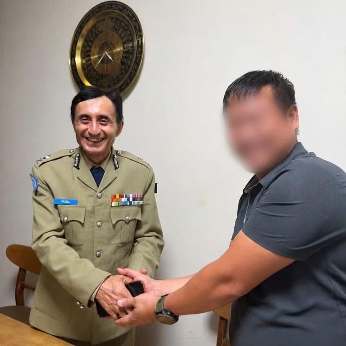 Ông Faisal Shahkar nhận lại chiếc điện thoại không may đánh rơi.