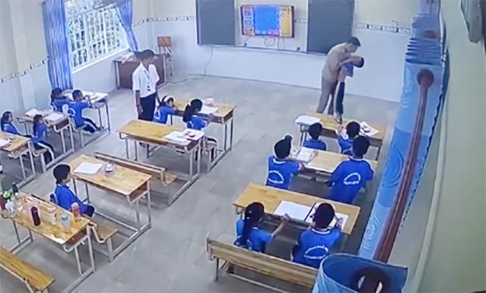 Giáo viên người Nga nhấc bổng một học sinh, đưa ra khỏi lớp học. Ảnh cắt từ clip