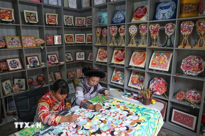 Các "họa sỹ nông dân" vẽ tranh tại huyện Thủy Thành, tỉnh Quý Châu, Trung Quốc. (Ảnh: THX/TTXVN phát)