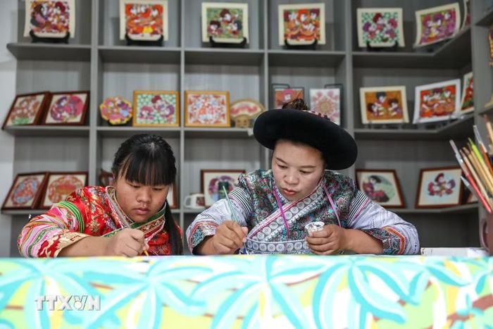 Các "họa sỹ nông dân" vẽ tranh tại huyện Thủy Thành, tỉnh Quý Châu, Trung Quốc. (Ảnh: THX/TTXVN phát)